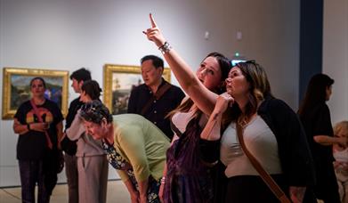 People looking and pointing at artworks in the gallery
