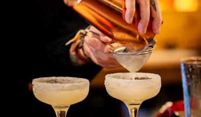 A bartender making some margaritas
