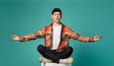 Matt Richardson sat on a white box with a green background