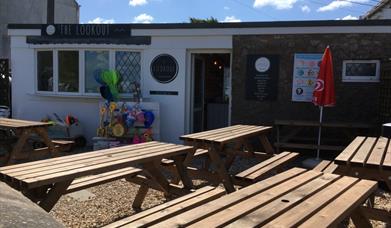 Exterior of cafe with tables outside.