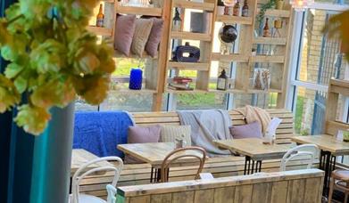 Malthouse interior, wooden seating and hanging plants.