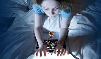 A young girl typing on a laptop