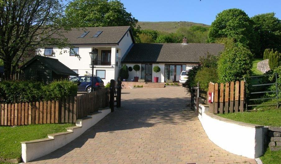 Exterior of a large house with lots of trees.