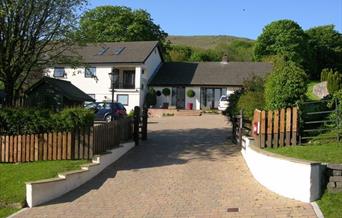 Exterior of a large house with lots of trees.