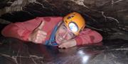 A man exploring local caves with Gower Adventures