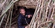 Dryad Bushcraft man drinking coffee in wood tent