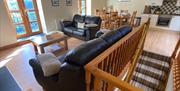 Hael Farm Cottages upstairs area with sofas and kitchen