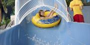 LC Swansea girl riding inflateable on water slide