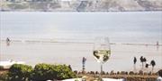Oxwich Bay Hotel fish dish with glass of wine overlooking bay