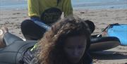 Progress Surf School class learning on beach