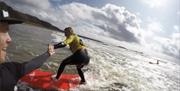 Progress Surf School surfer high fiving instructor