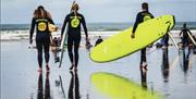 Progress Surf School surfing class walking towards water