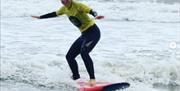 Progress Surf School young girl standing on surfboard