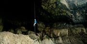Savage Adventures abseiler in front of cave