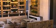 Malthouse interior, wooden seating and hanging plants.