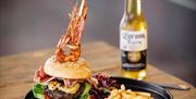 The Secret Beach Bar burger and fries with bottle of beer