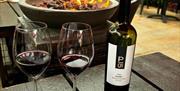 The Wine House firepit with bottle of red wine and two glasses