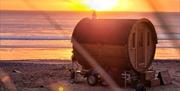 Ty Sawna sauna pod on beach at sunset