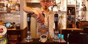 A bartender waiting to serve a customer at Gower Inn