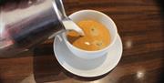 A cup of coffee being poured at Bank Farm Coffee Lounge